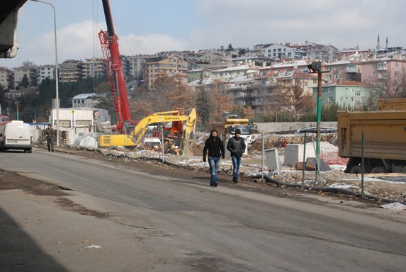 Öğrenciler, inşaat alanının yanında akan trafiğin ortasında.